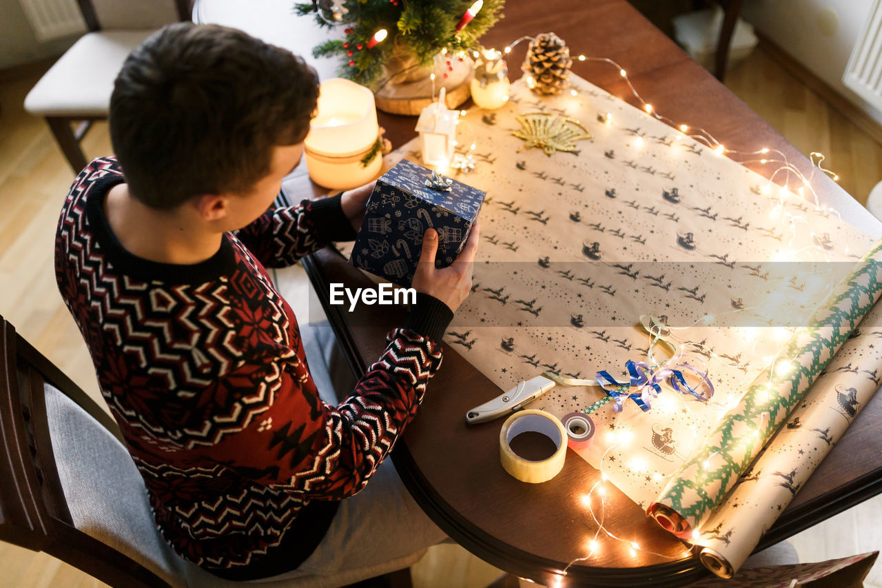 Young man packs christmas presents for friends and family