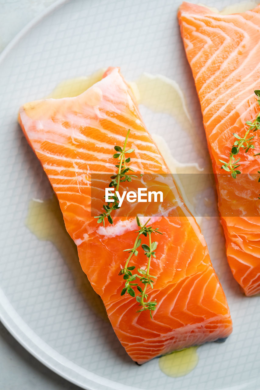 Fresh salmon fillet with herbs on a plate for delicious salmon steak.