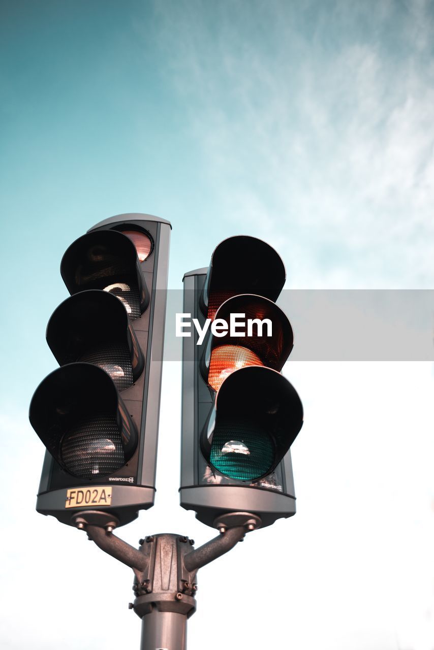 Low angle view of road signal against sky