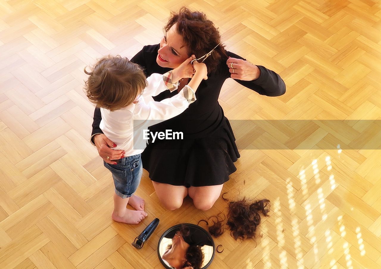 High angle view of woman and son on hardwood floor at home