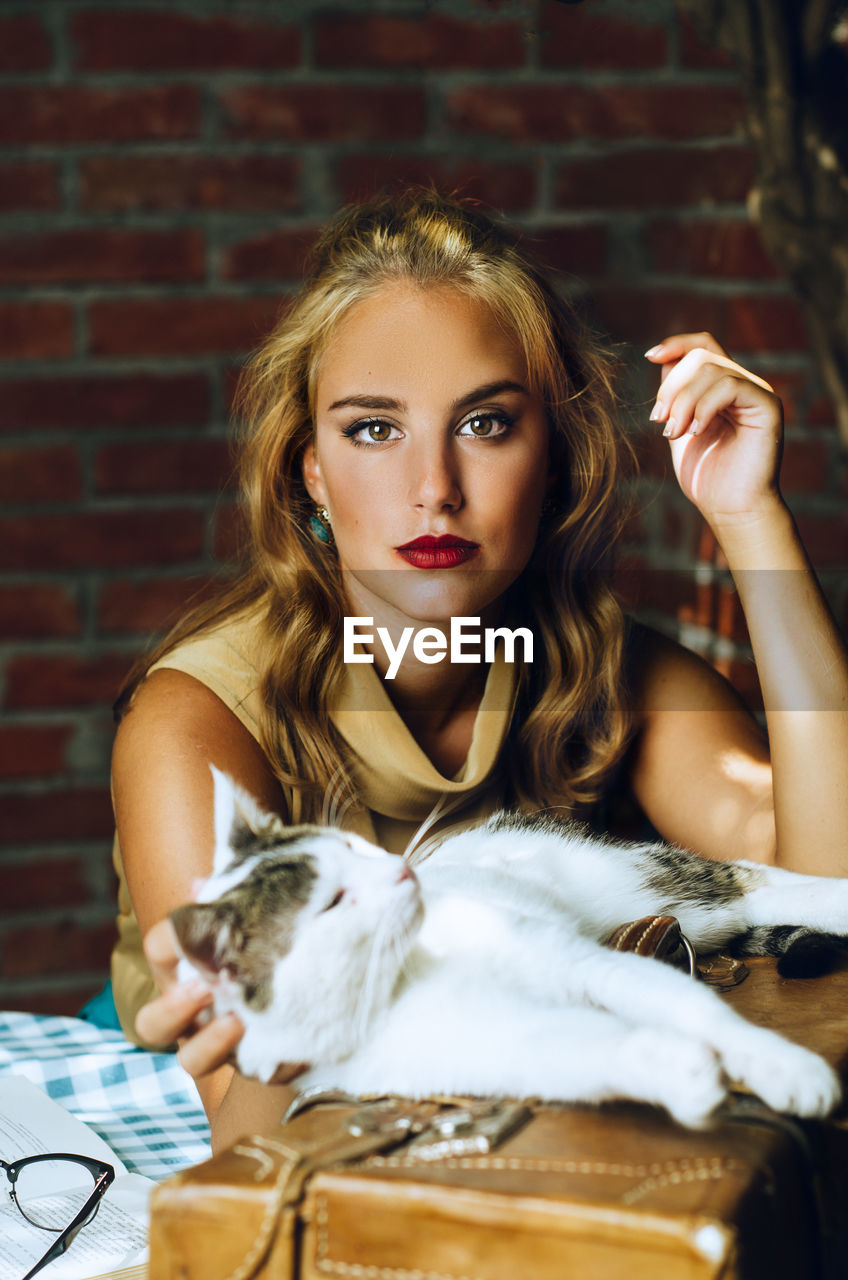 Portrait of young woman with cat