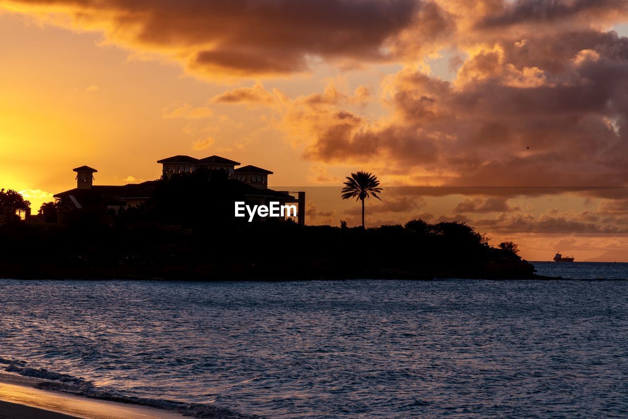 scenic view of sea against cloudy sky during sunset