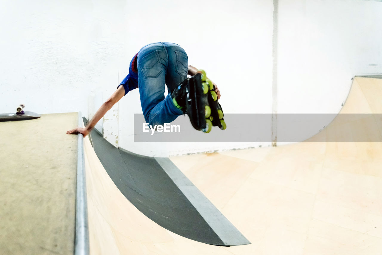 MIDSECTION OF MAN SKATEBOARDING ON SKATEBOARD