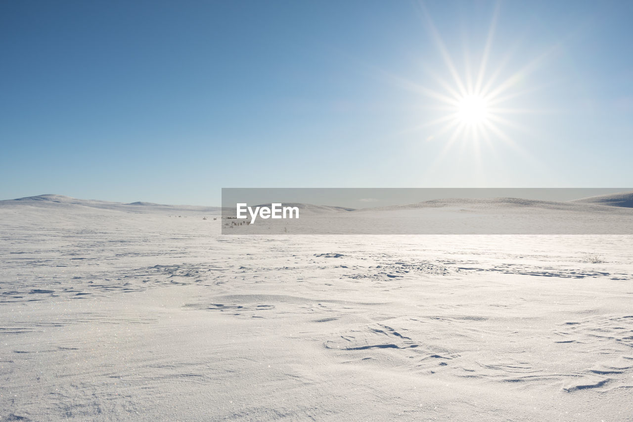 Scenic view of snow covered landscape against clear sky during winter