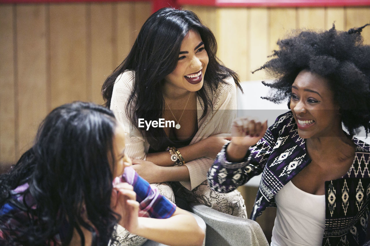 Three young women hanging out at a bowling alley