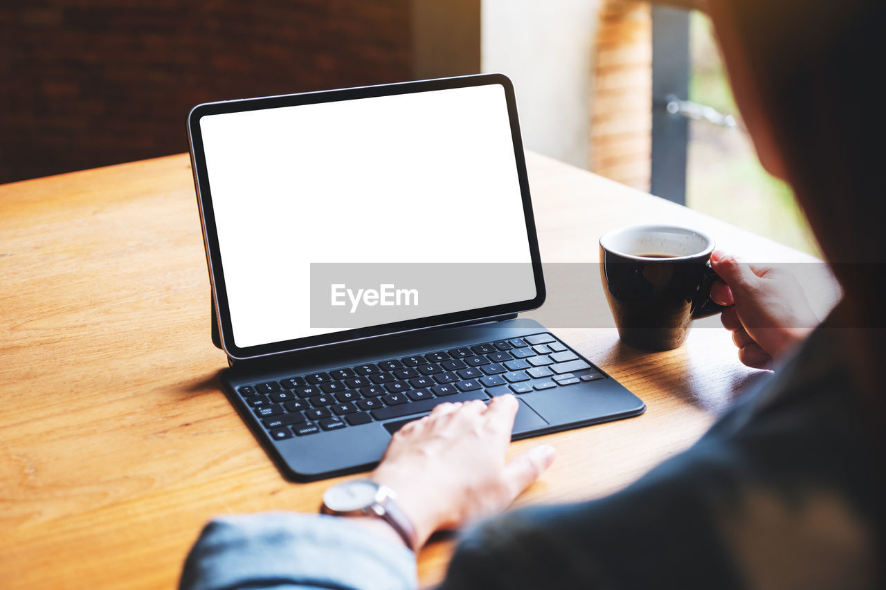 midsection of man using laptop at table