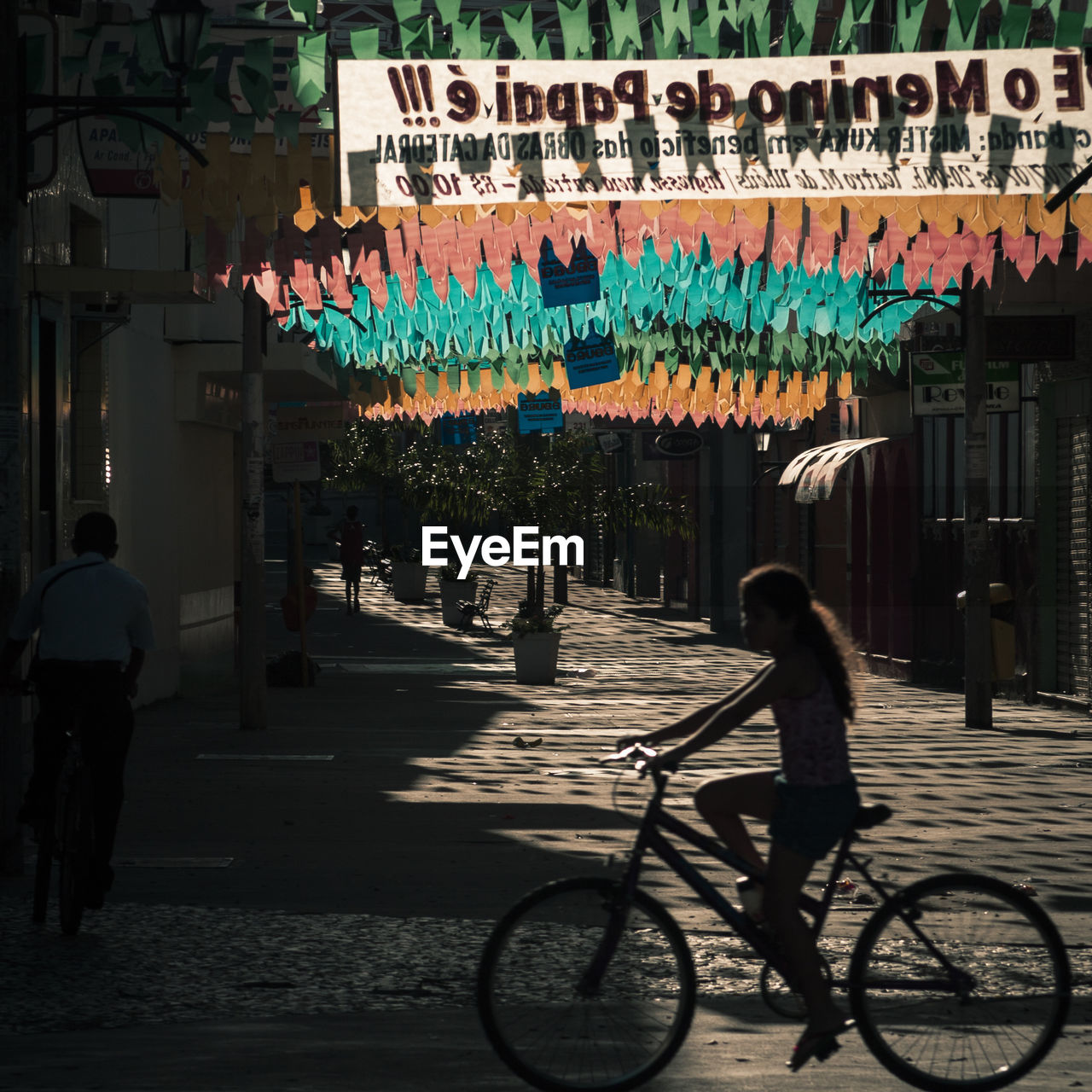 PEOPLE WALKING ON ILLUMINATED STREET