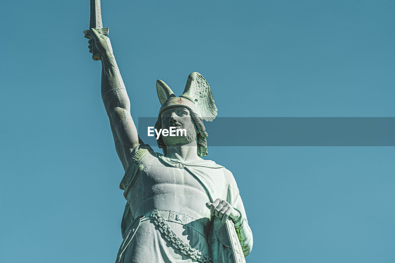 Low angle view of statue against blue sky