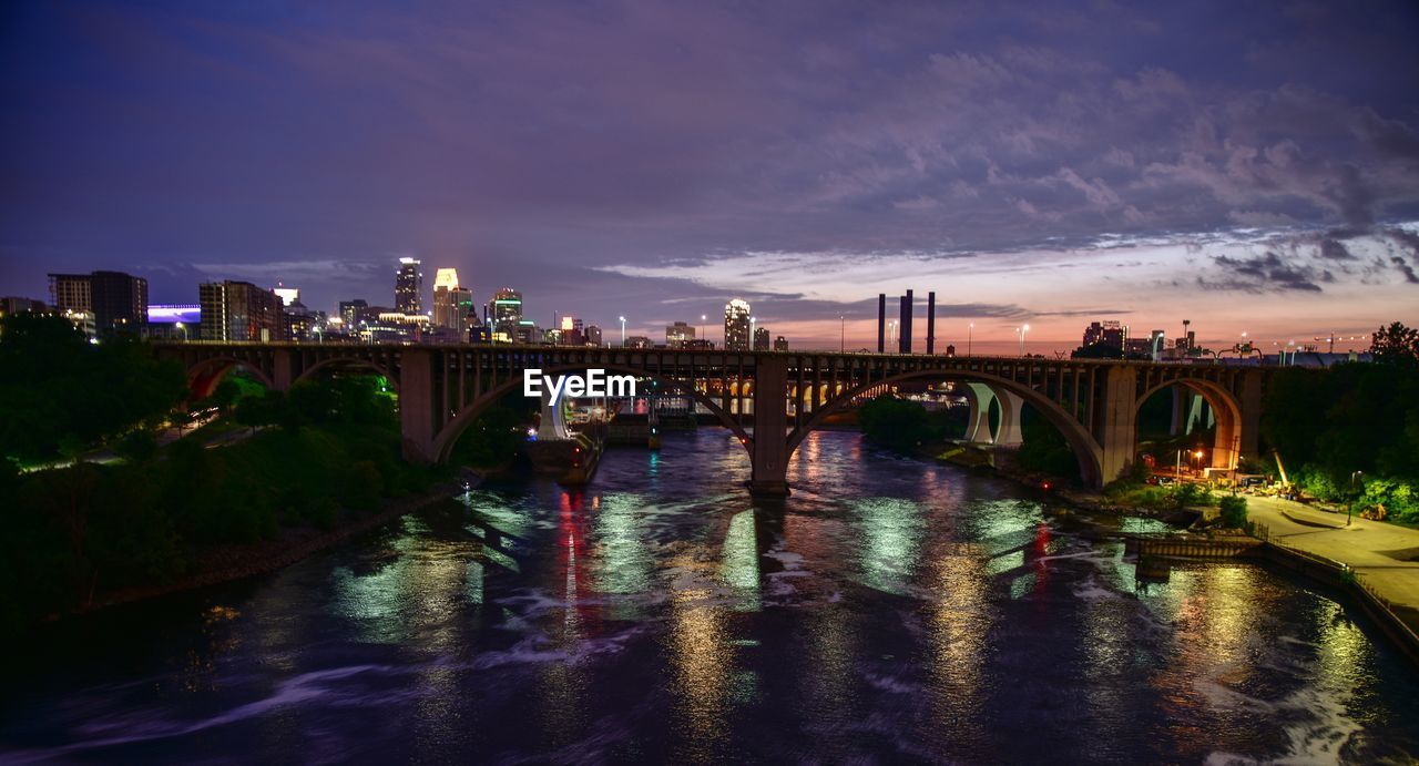 Bridge over river in city at night