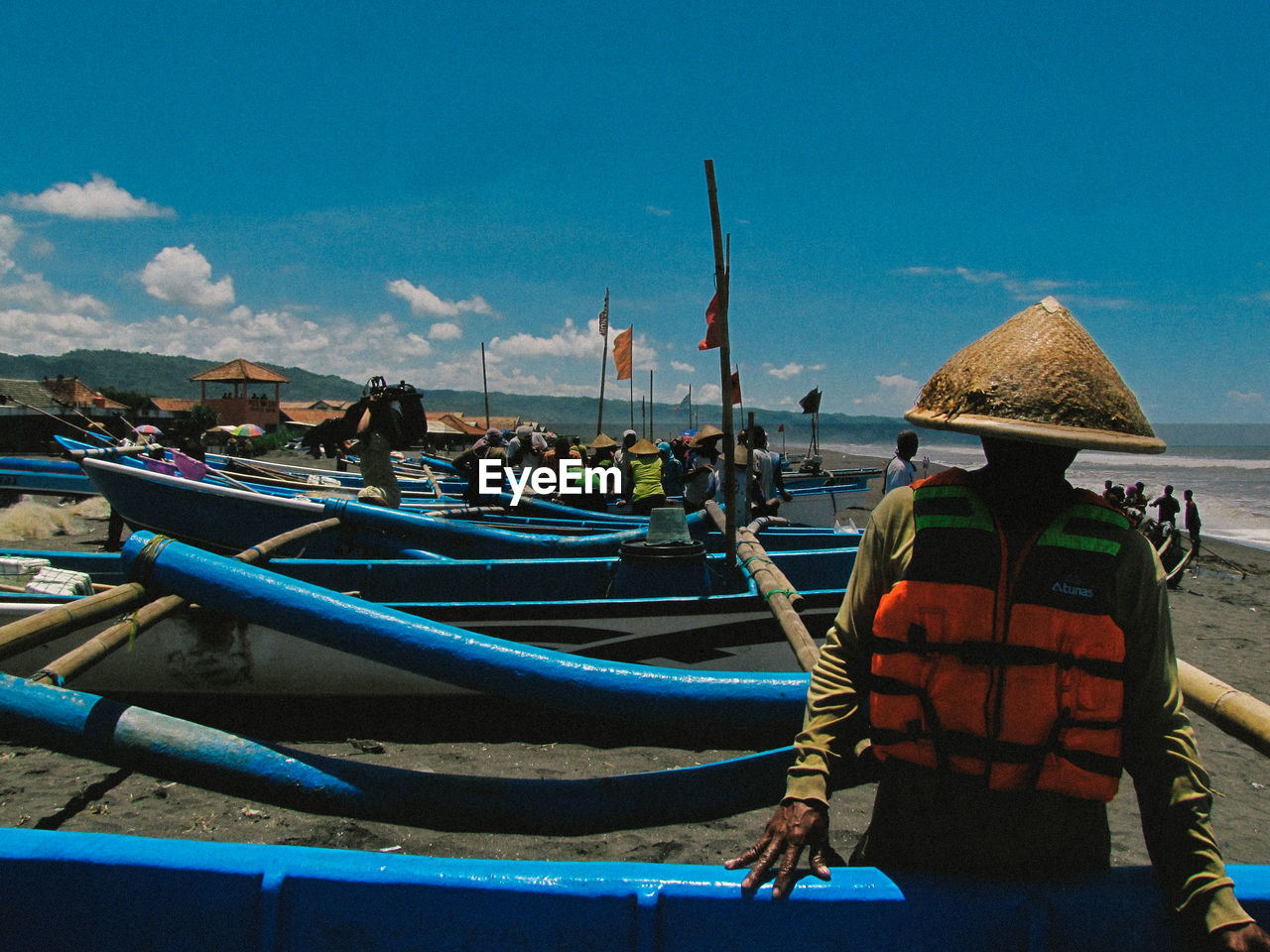 People standing by boats during sunny day