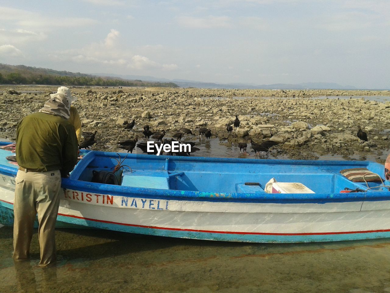 SIDE VIEW OF WOMAN ON BOAT AGAINST SKY