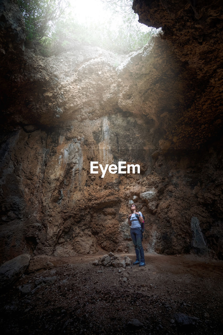 Real view of woman walking in cave. 
hiker explores cave