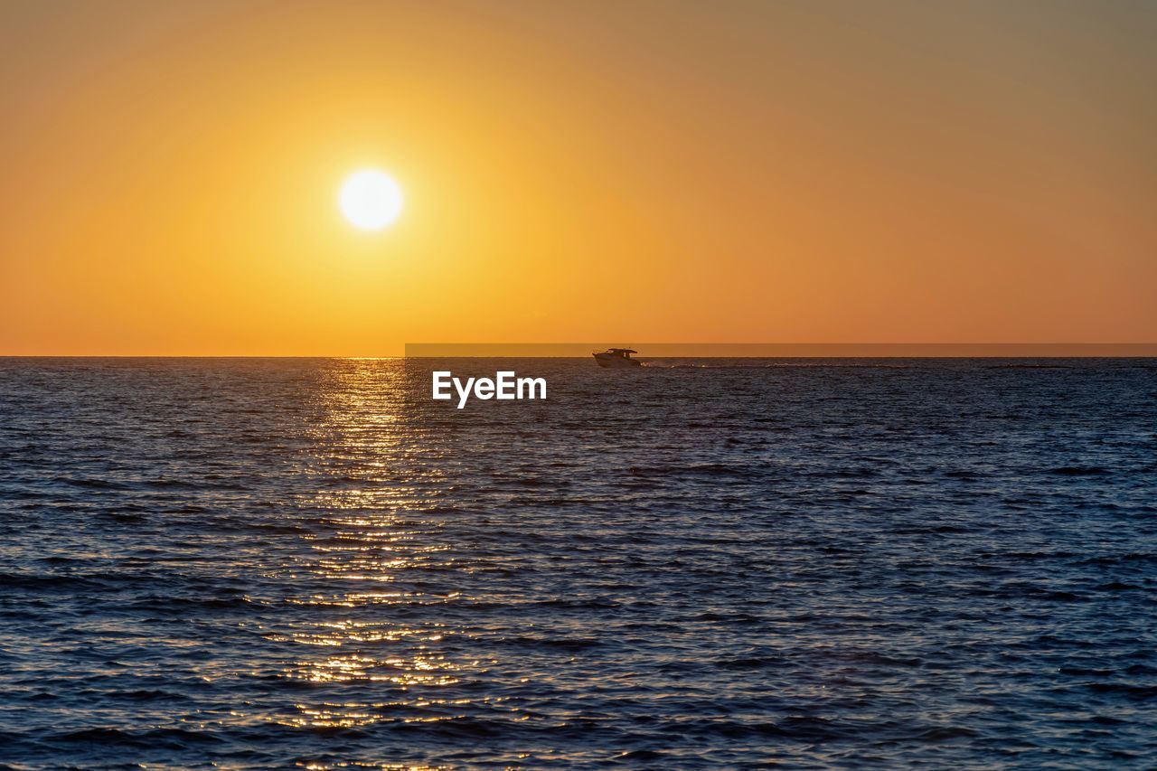 Scenic view of sea against orange sky