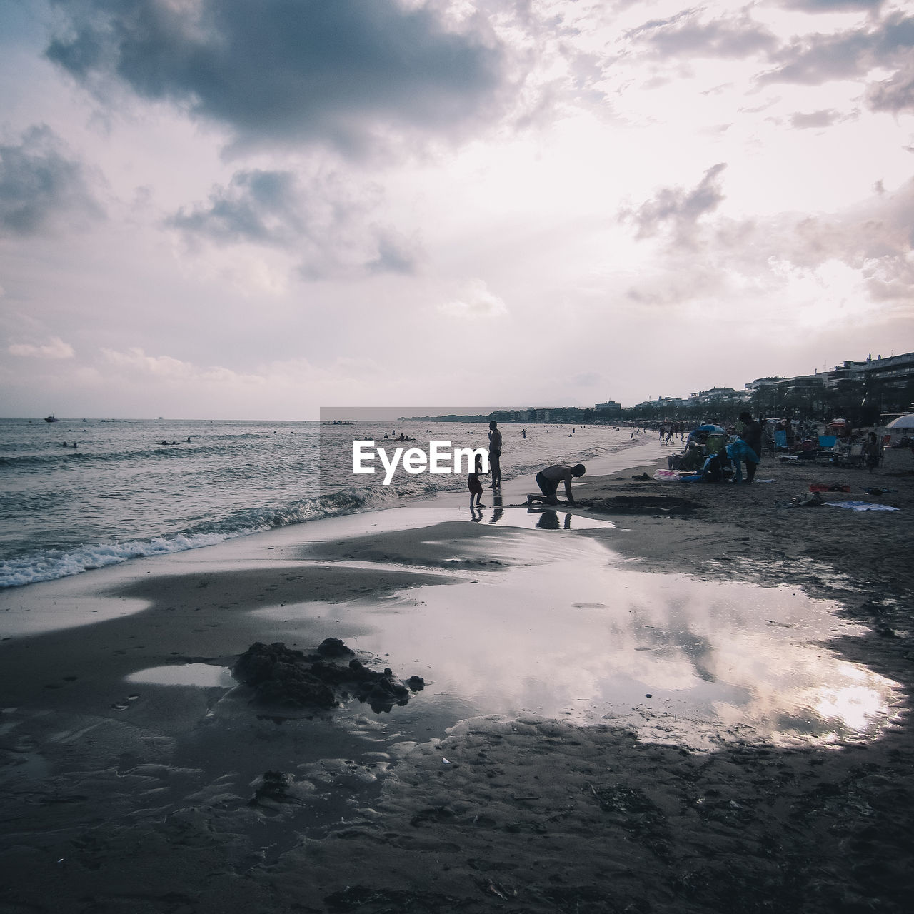 People at beach against sky