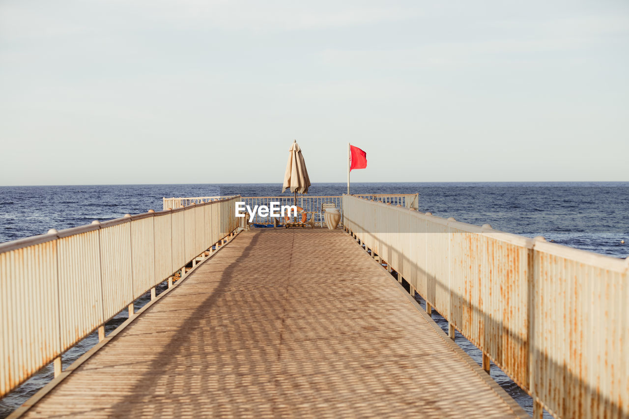 PIER ON SEA SHORE AGAINST SKY