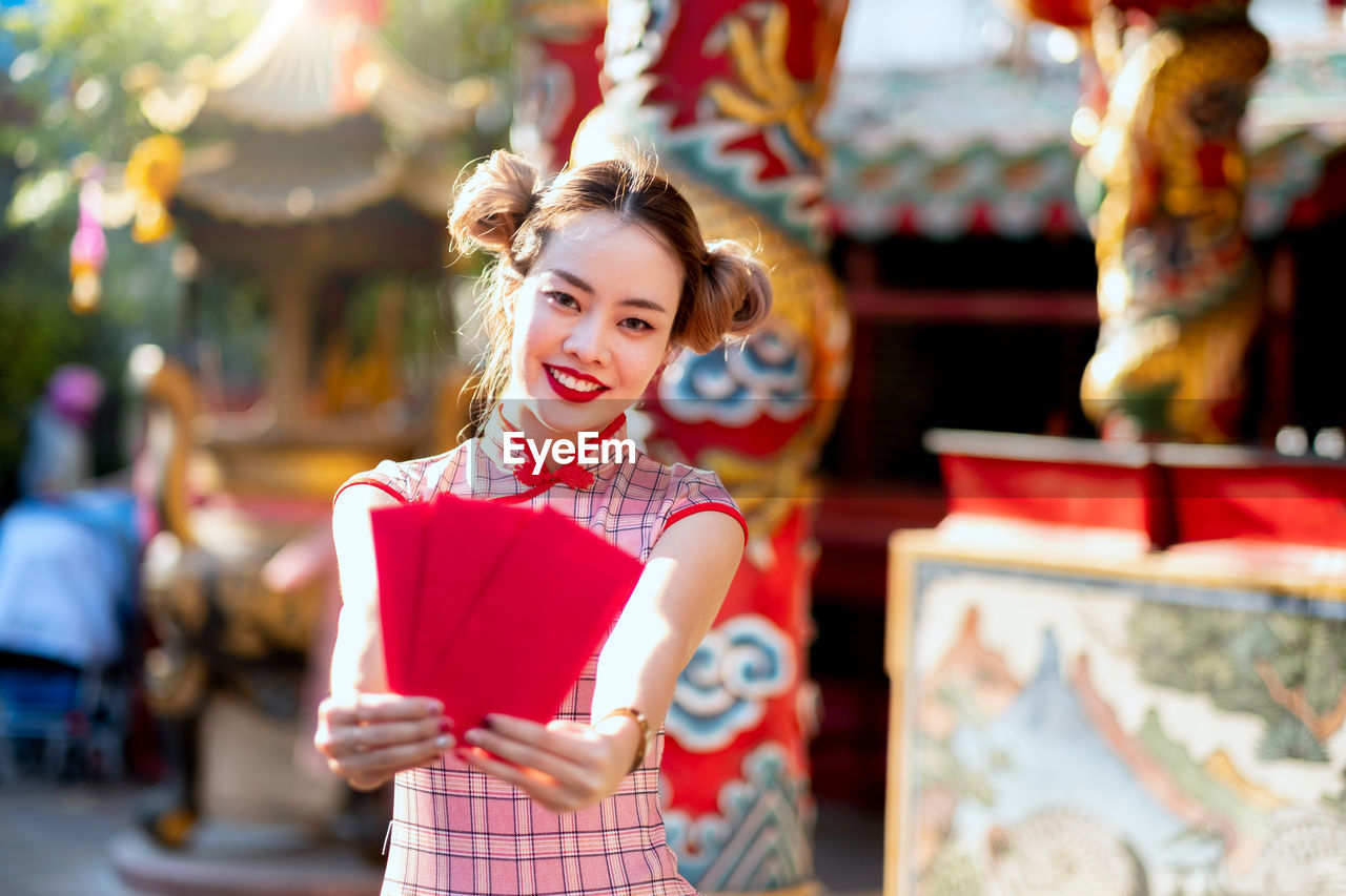 Portrait of smiling woman with red envelope during chinese new year