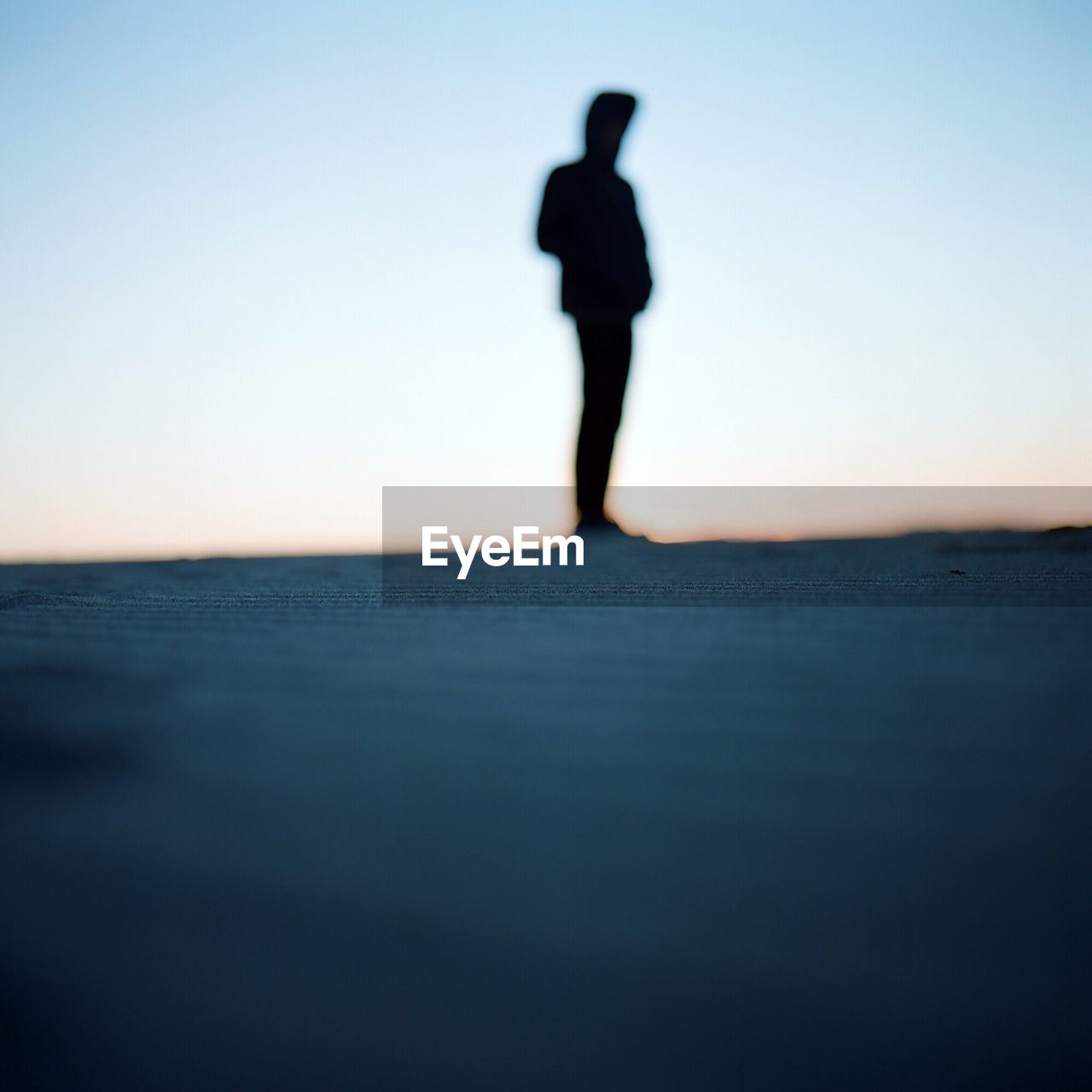 Silhouette person standing at field against clear sky