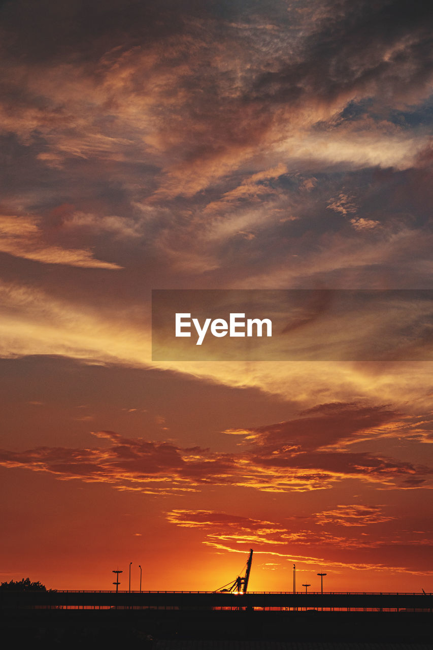 SCENIC VIEW OF DRAMATIC SKY OVER SILHOUETTE LANDSCAPE DURING SUNSET