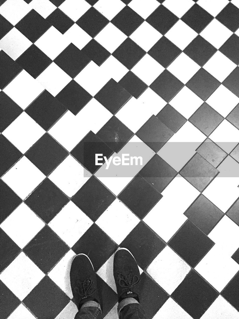 Low section of person standing on patterned floor