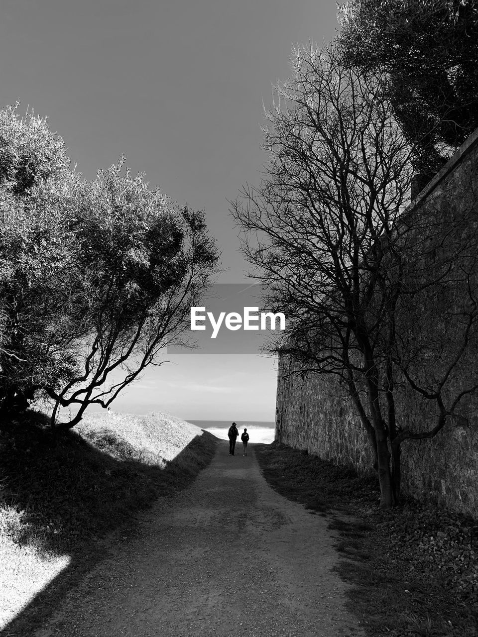 PEOPLE WALKING ON ROAD AGAINST SKY