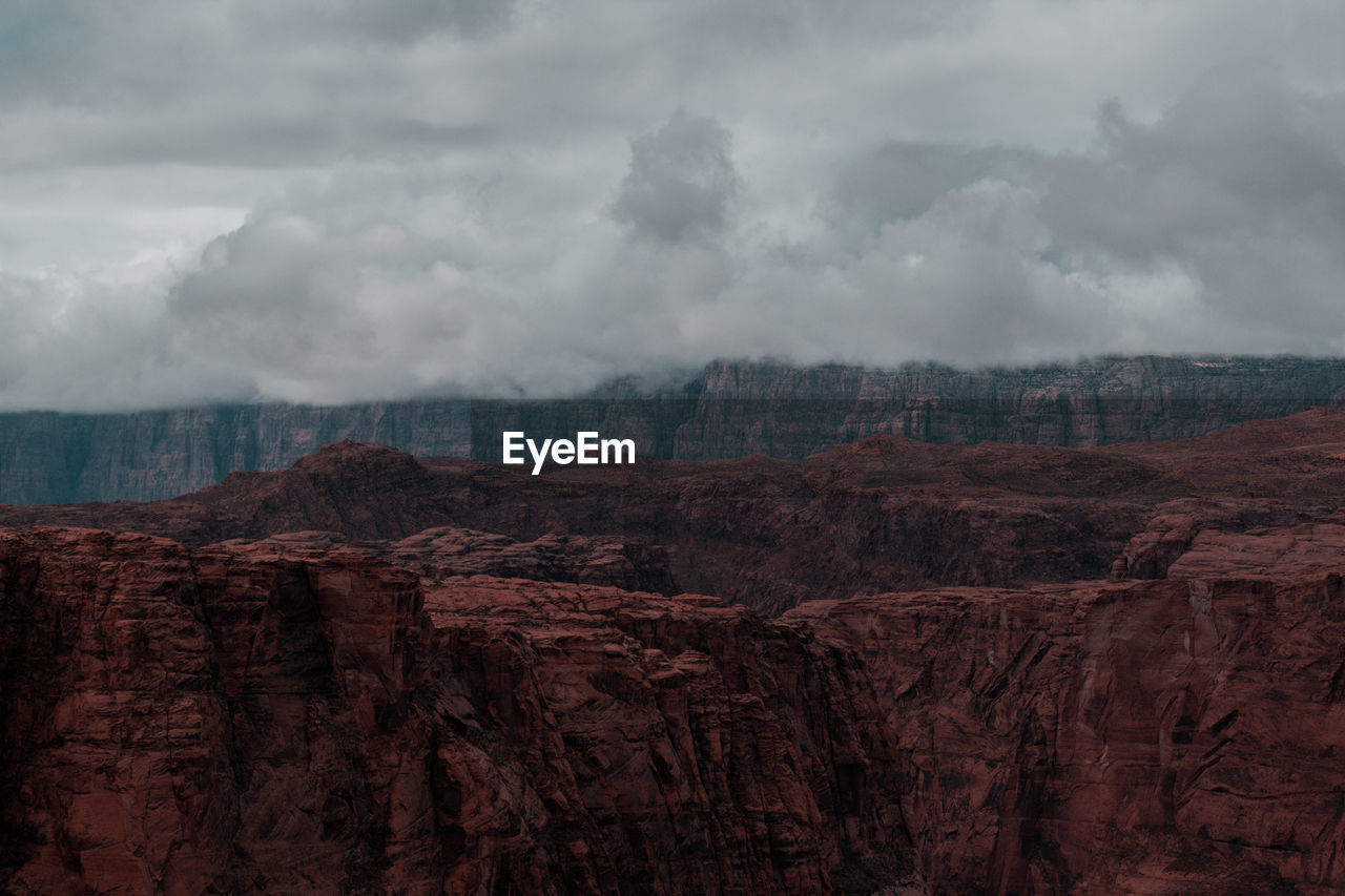 Scenic view of rocky mountains against cloudy sky