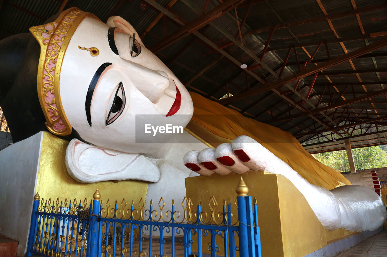 LOW ANGLE VIEW OF STATUE AGAINST TEMPLE BUILDING