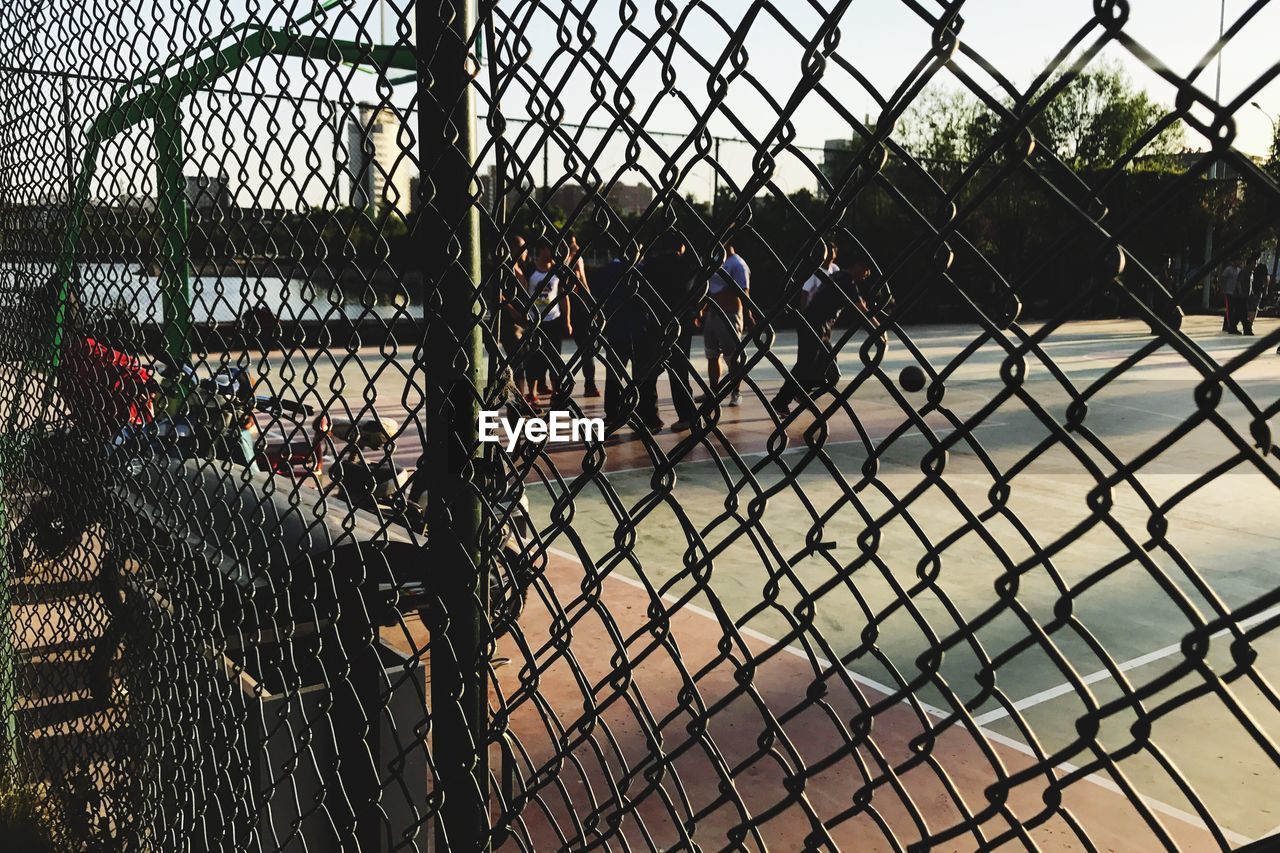 CLOSE-UP OF CHAINLINK FENCE AGAINST SKY