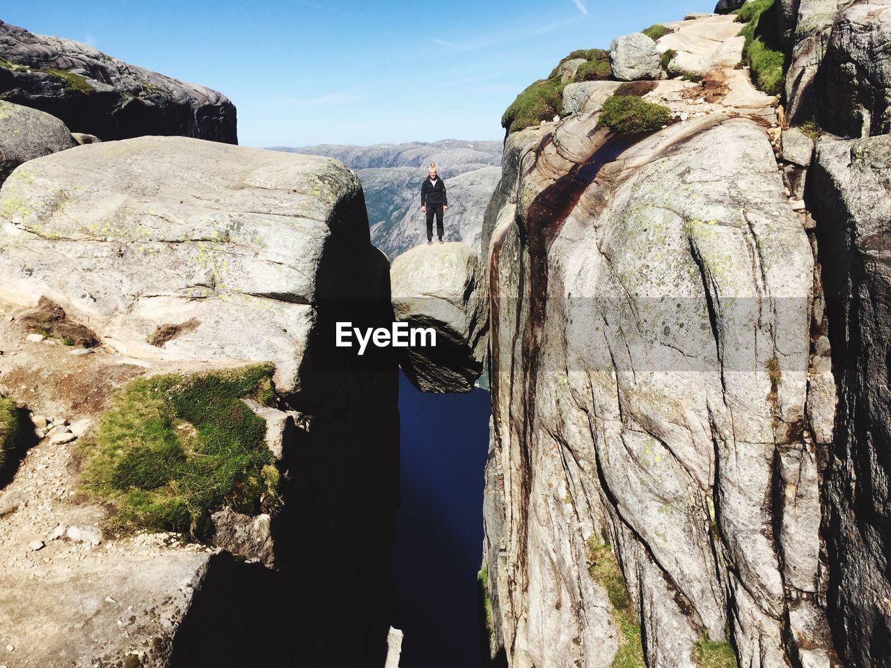 Rear view of man on cliff against sky