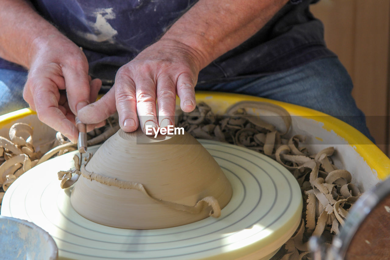 Midsection of man making pot