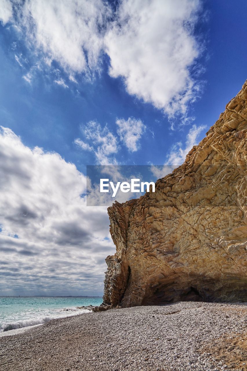 sky, land, sea, cloud, rock, water, beach, coast, scenics - nature, nature, beauty in nature, ocean, shore, cliff, landscape, travel destinations, environment, sand, terrain, no people, tranquility, rock formation, travel, blue, horizon, tranquil scene, coastline, outdoors, day, body of water, non-urban scene, tourism, mountain, wave, holiday, idyllic, geology, bay