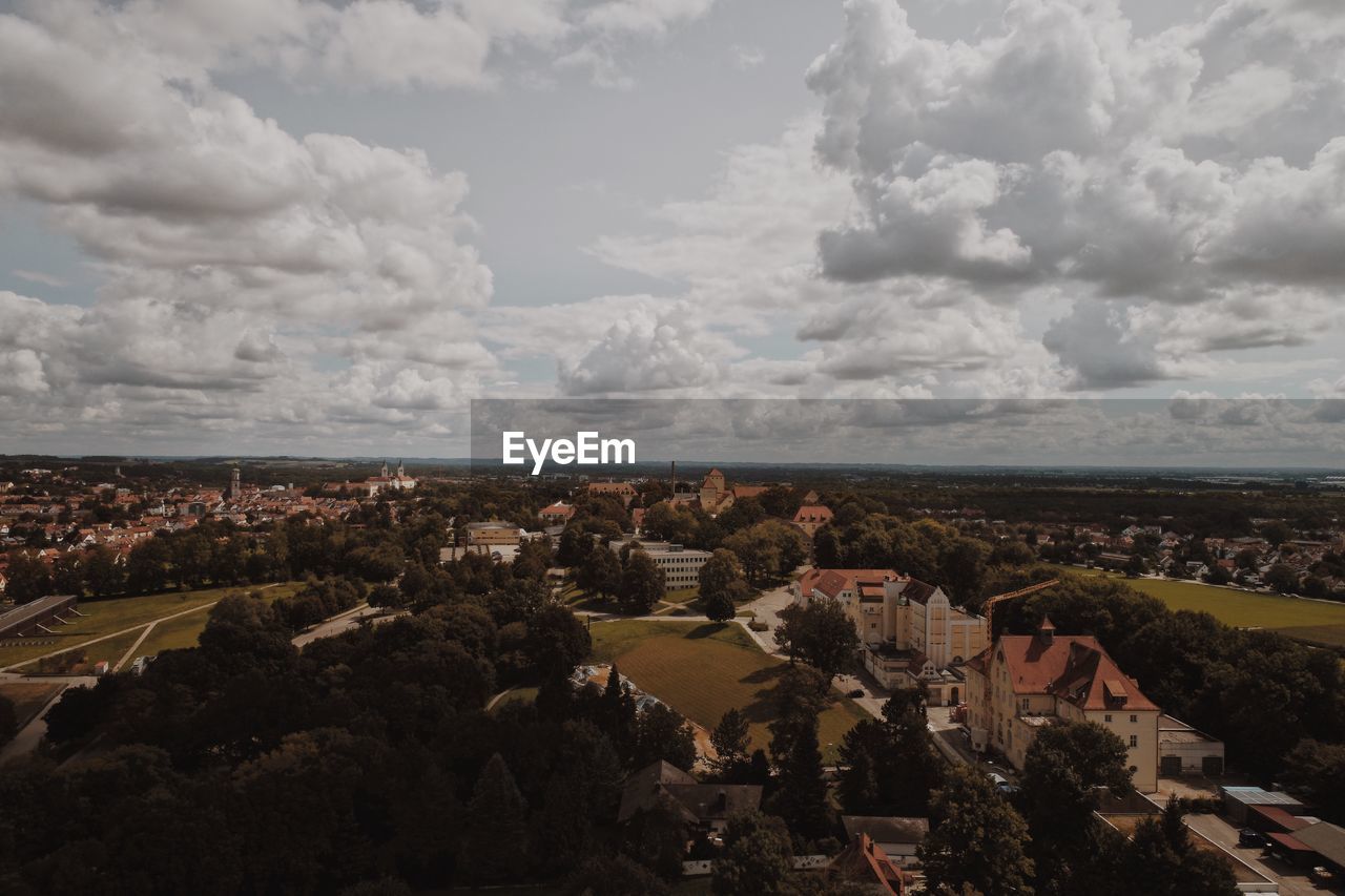 Aerial view of cityscape against cloudy sky