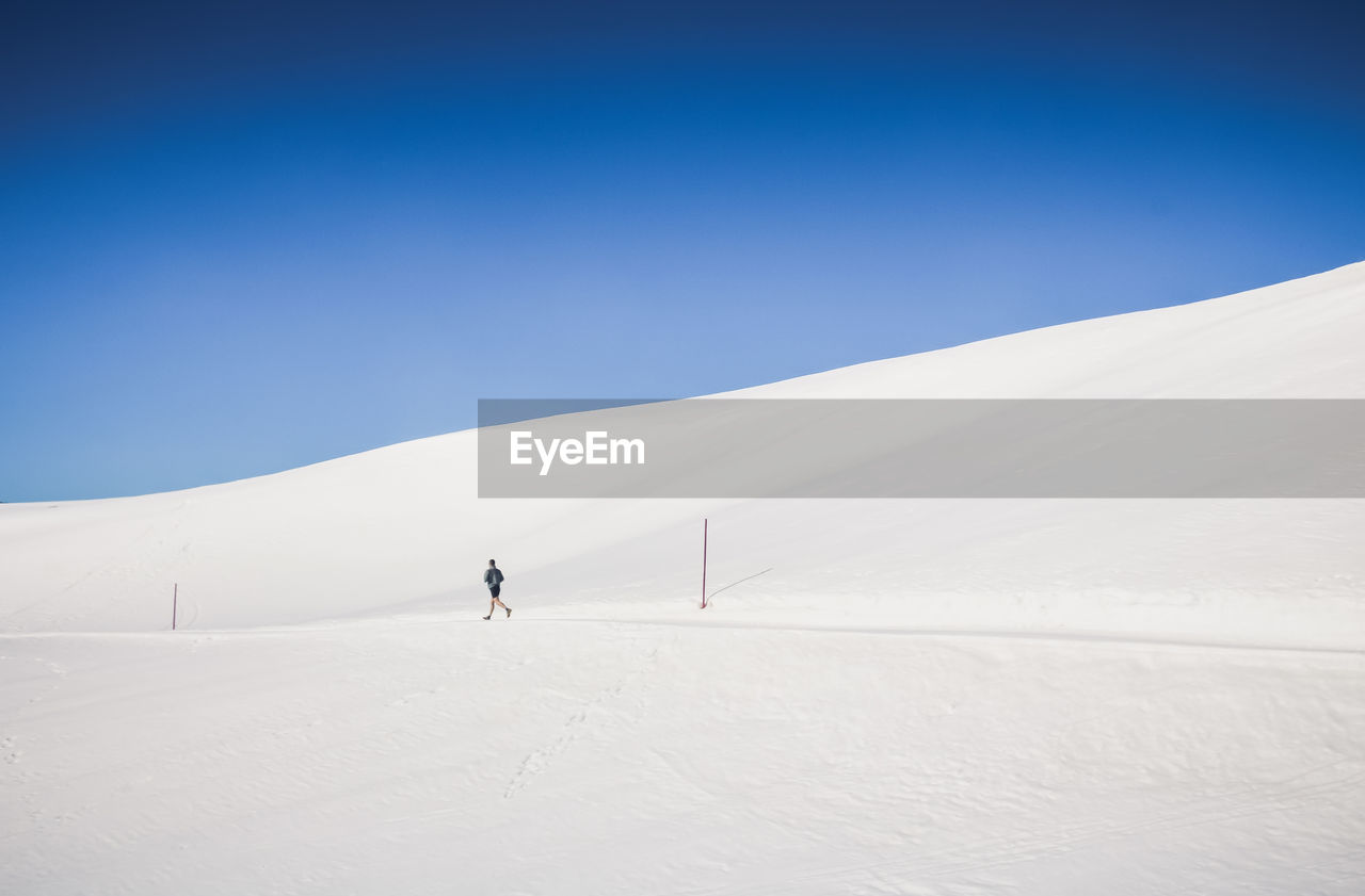 Scenic view of snowcapped mountains against clear blue sky