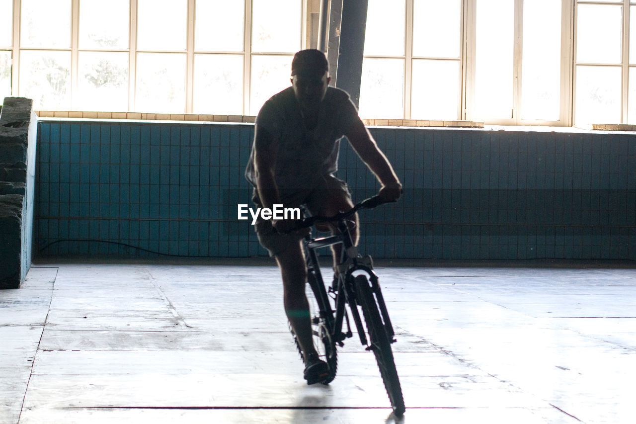 Man riding bicycle in building