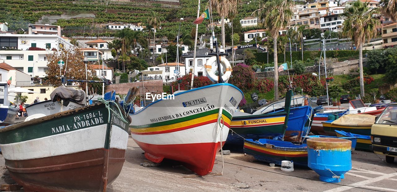 BOATS MOORED AT HARBOR BY BUILDINGS