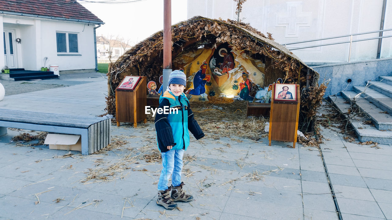 Smiling boy standing on footpath nativity scene