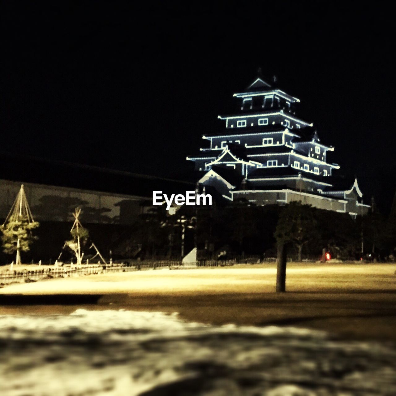 Low angle view of illuminated aizuwakamatsu castle against sky at night