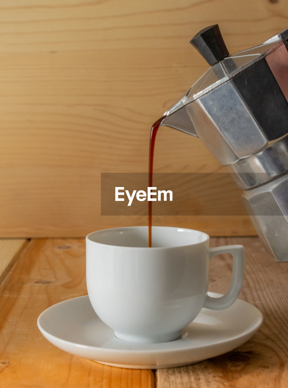 CLOSE-UP OF COFFEE CUP ON TABLE IN CAFE