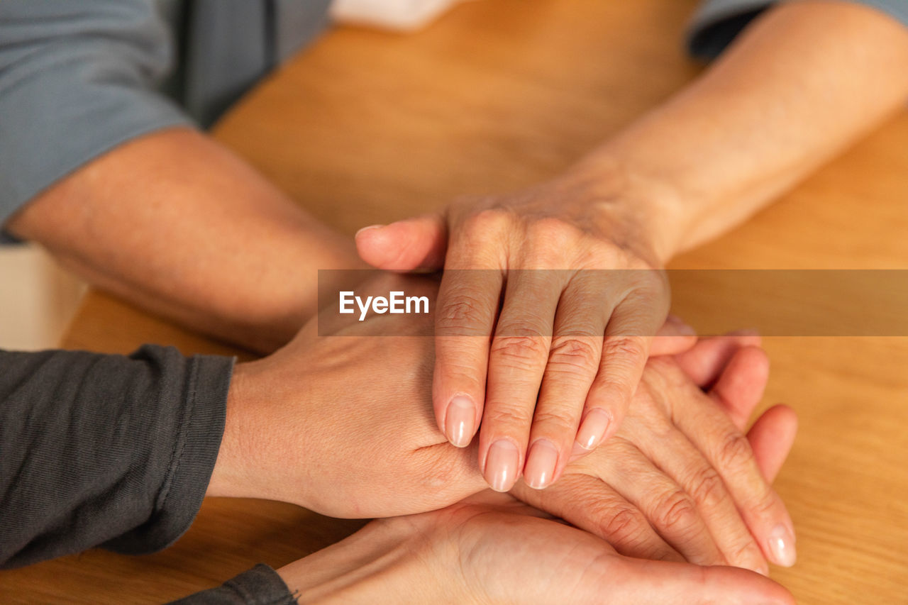 low section of people stacking hands