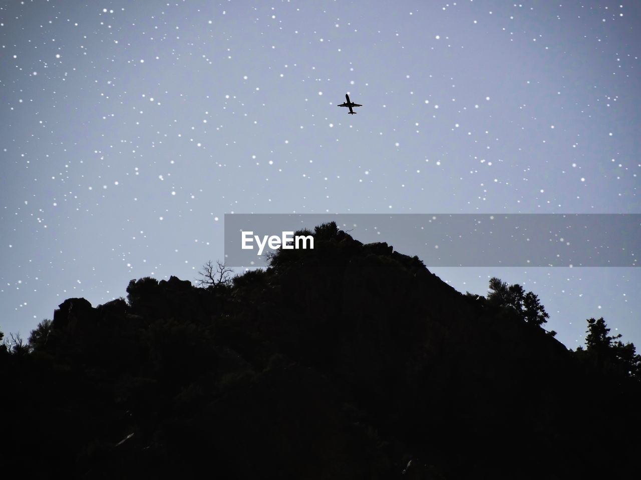 LOW ANGLE VIEW OF SILHOUETTE AIRPLANE FLYING AGAINST CLEAR SKY