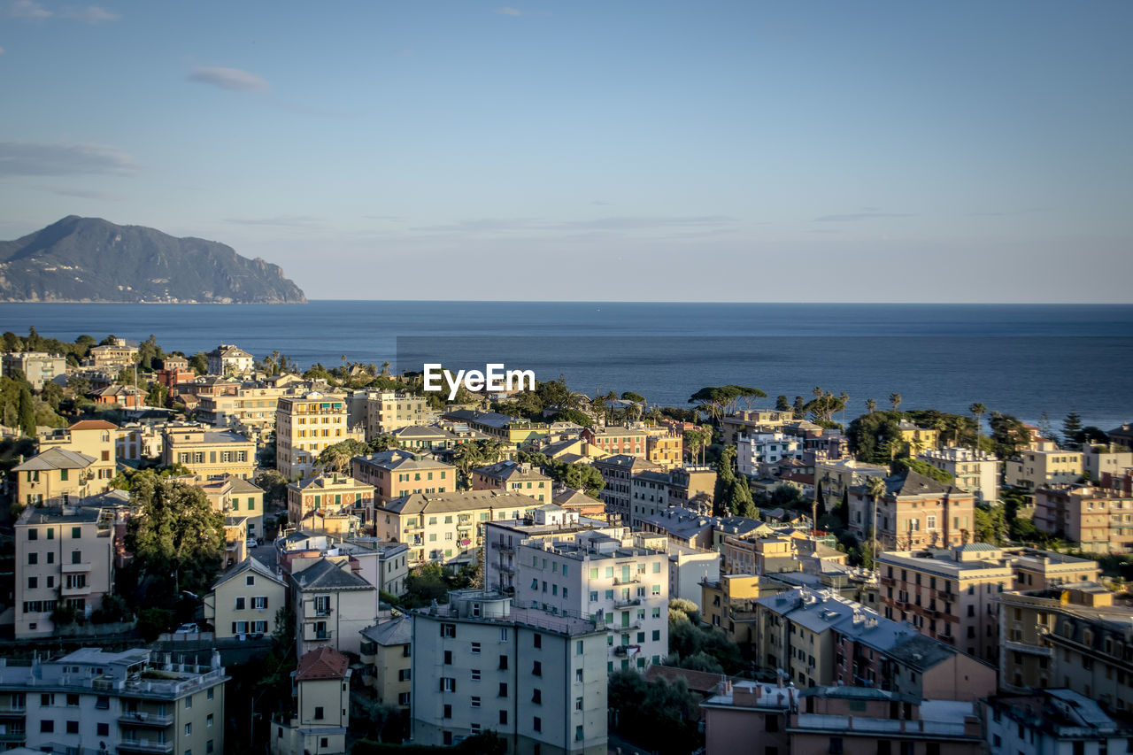 High angle view of townscape by sea against sky