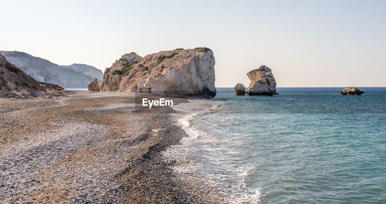 ROCKS ON SEA AGAINST CLEAR SKY