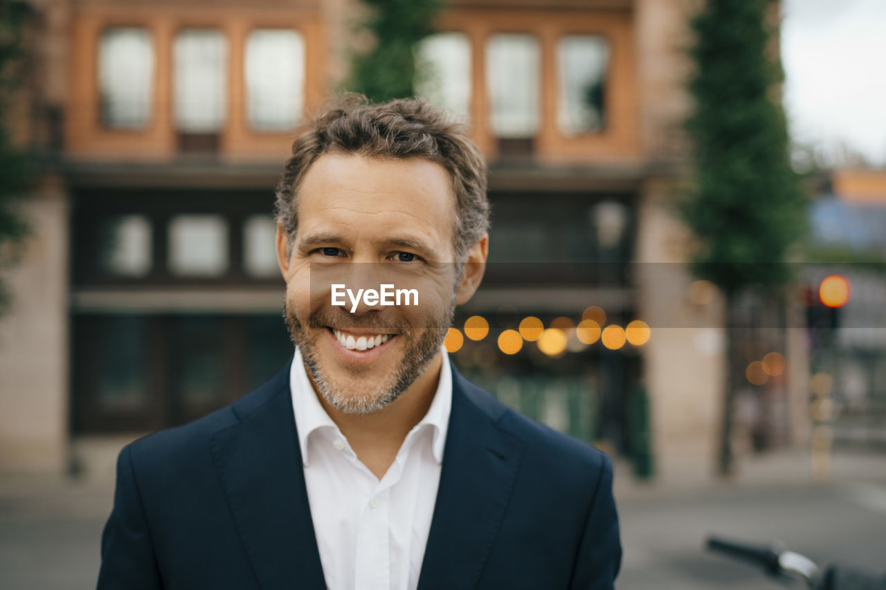 Portrait of smiling businessman in city