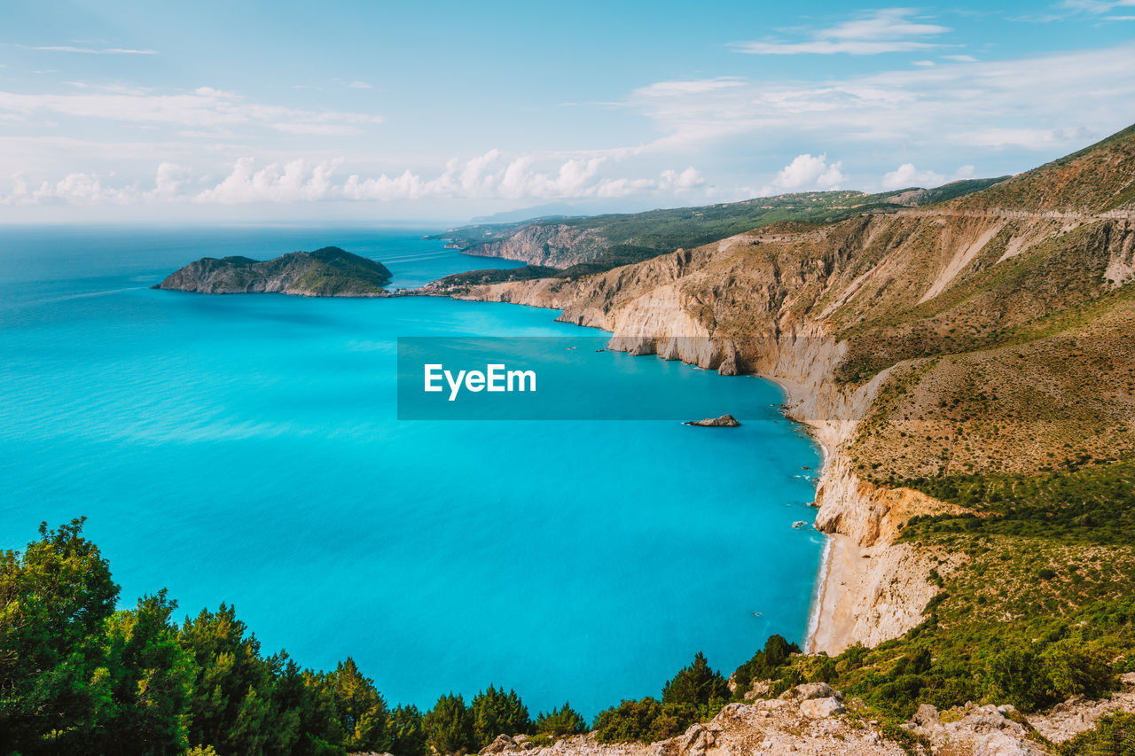 Scenic view of sea and cliff against sky