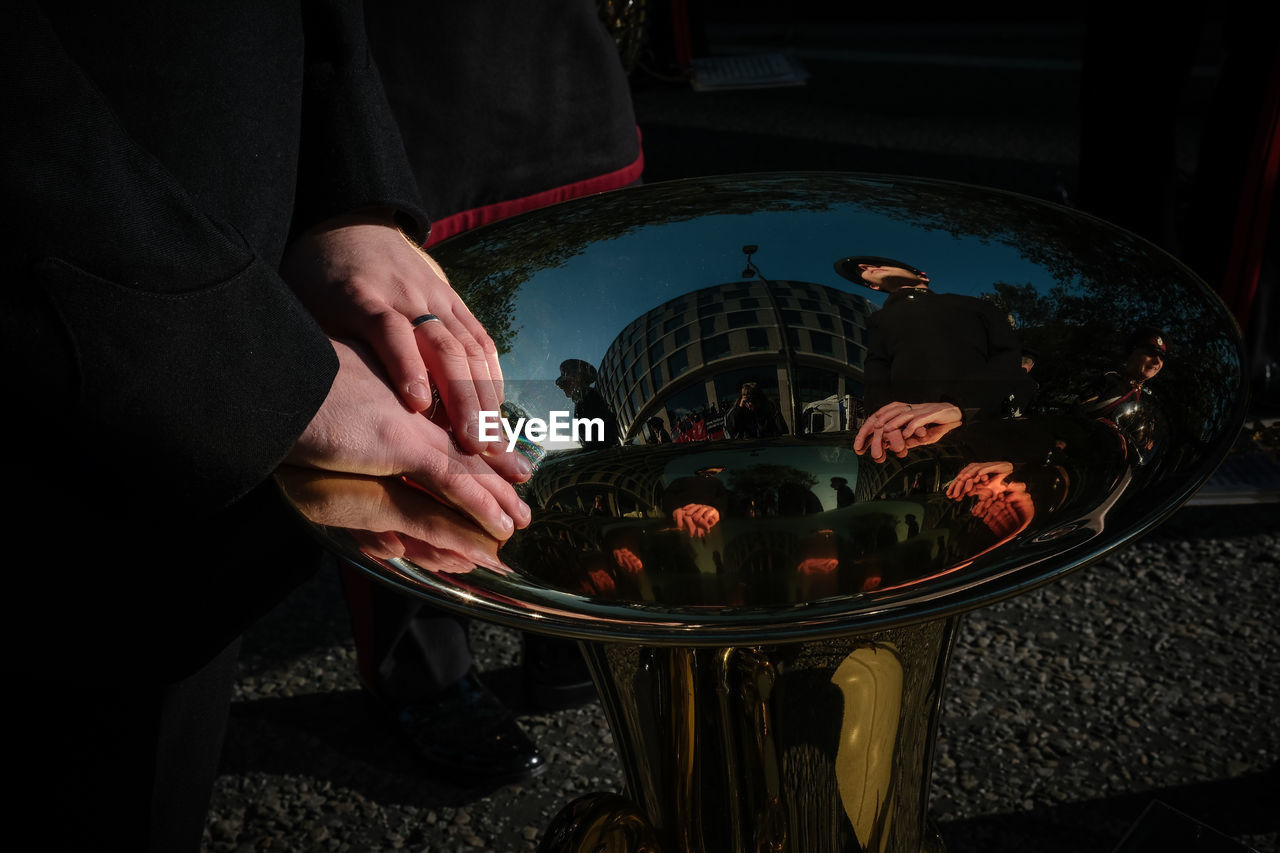 Close up of hands and reflections in mouth of trombone 