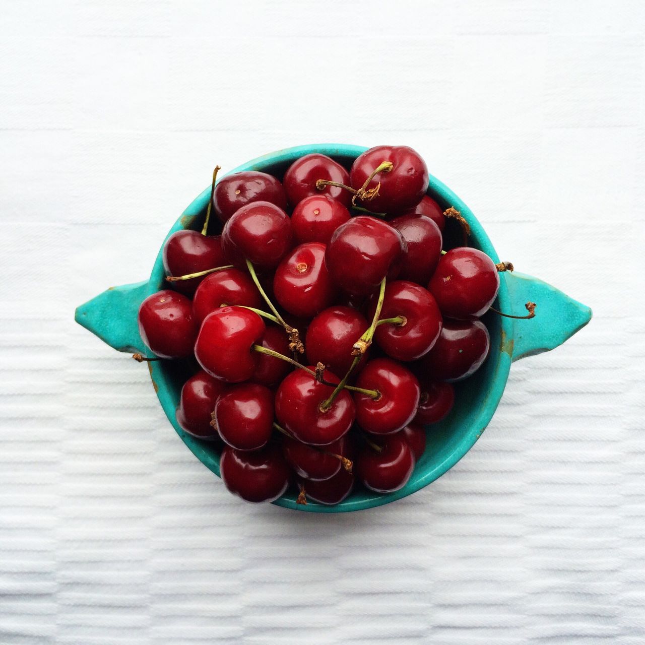 Directly above shot of cherries in bowl on floor