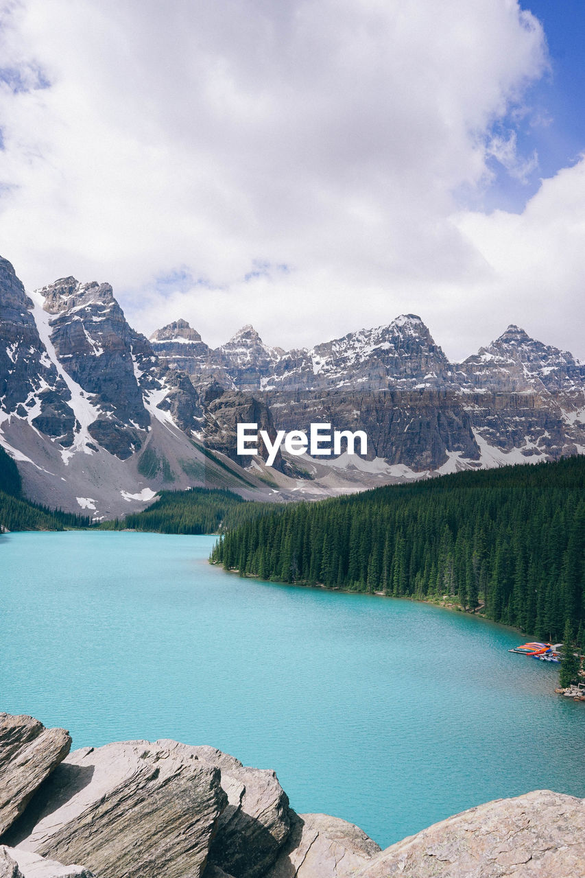 Scenic view of lake by mountains against sky