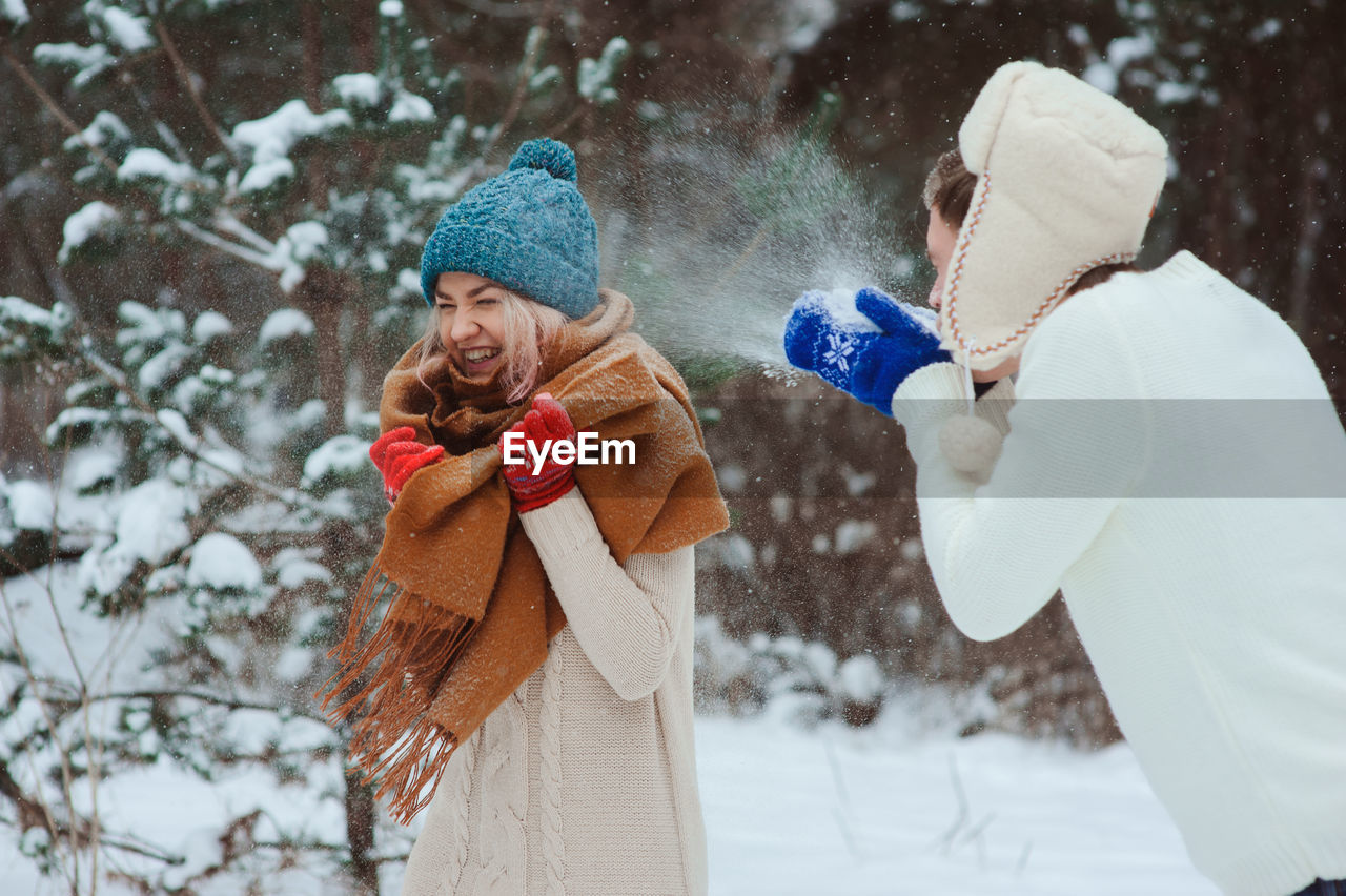Man and woman enjoying in snow during winter