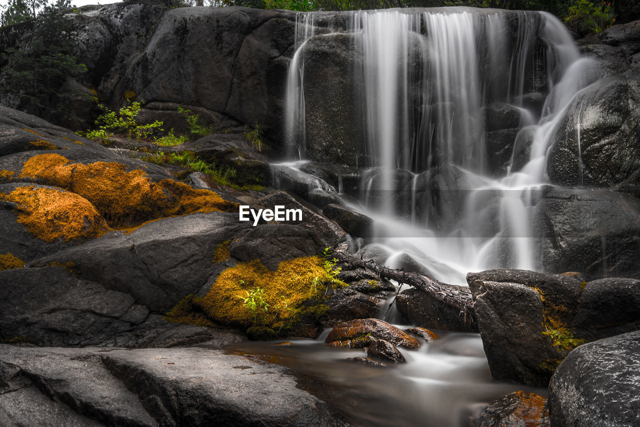 SCENIC VIEW OF WATERFALL ON ROCKS