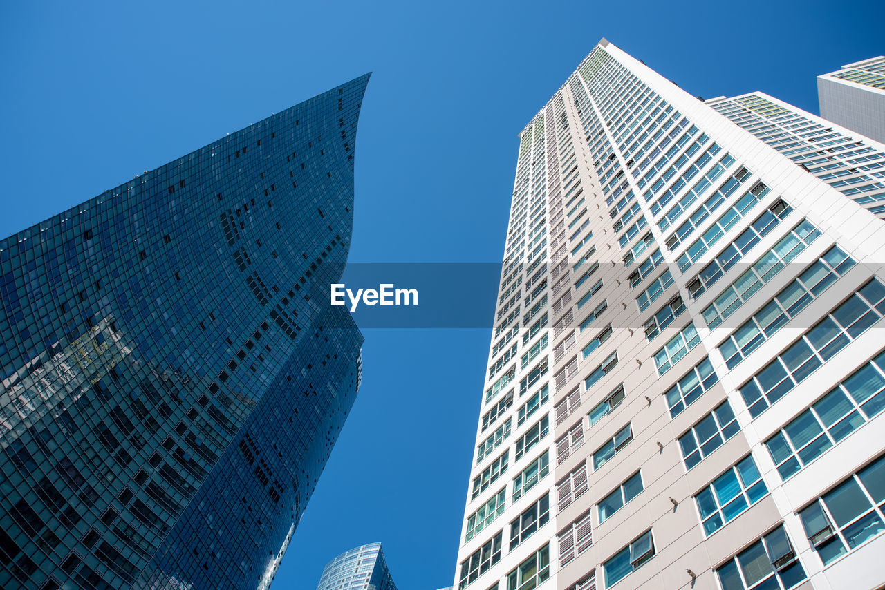 low angle view of modern buildings against clear blue sky