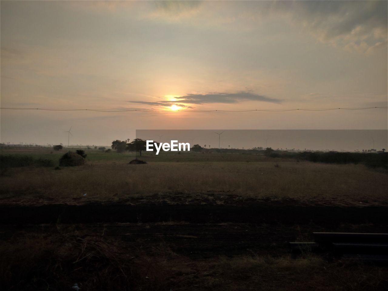 SCENIC VIEW OF SUNSET OVER FIELD